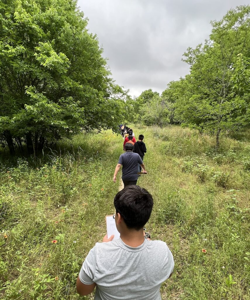 line of elementary students walking on a trail