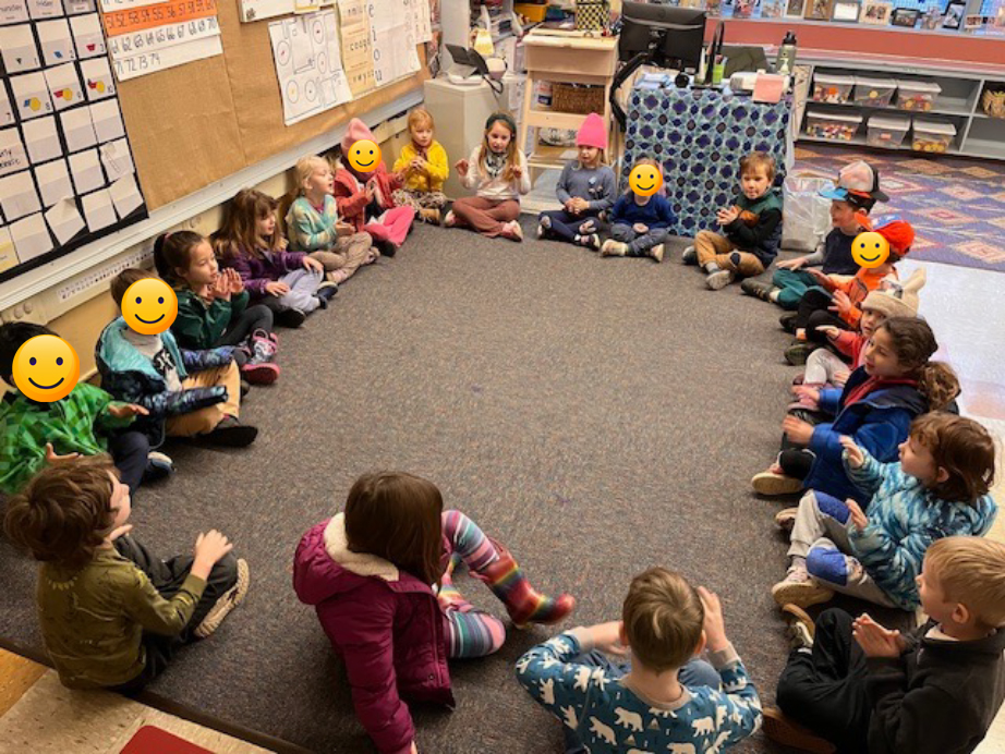 elementary class sitting on the floor in a circle singing