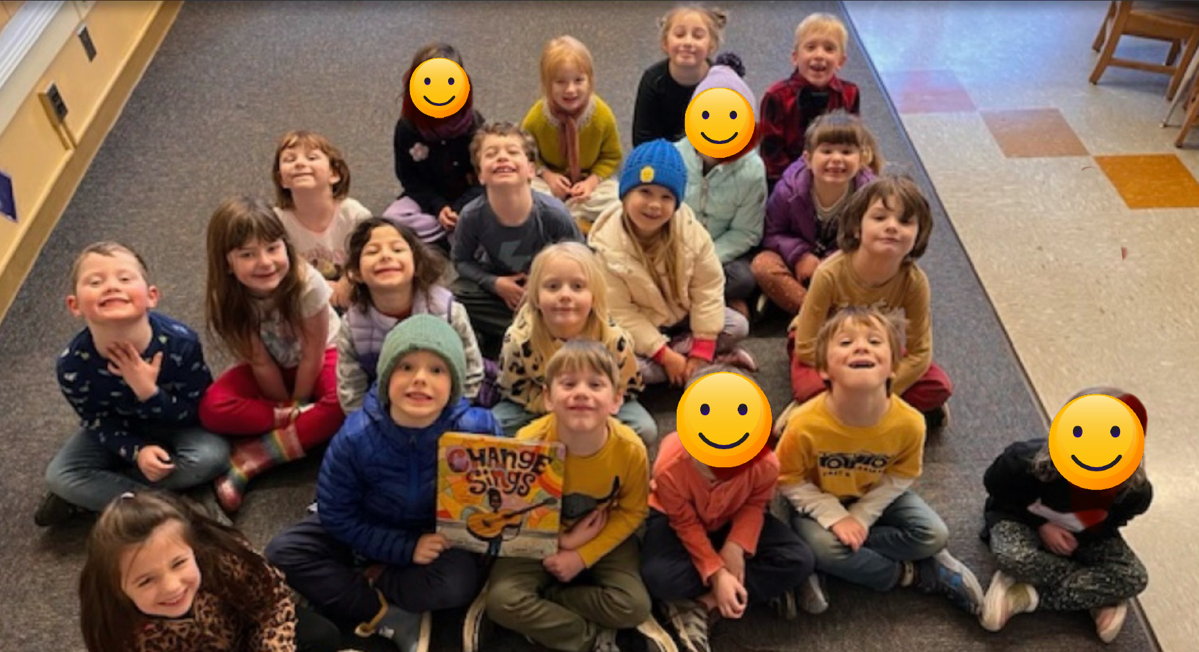 elementary class sitting on floor looking at the camera