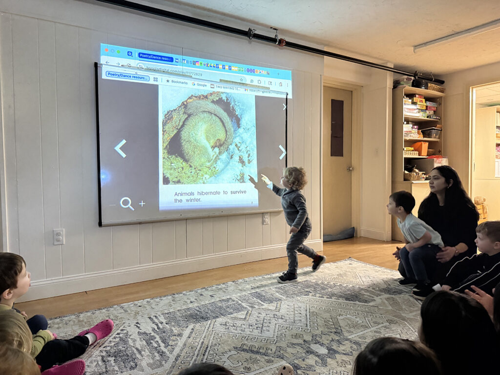 an elementary student pointing to an image on projection screen