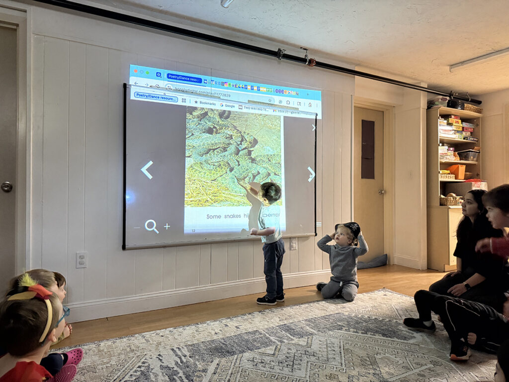 elementary students pointing out details on a projected screen