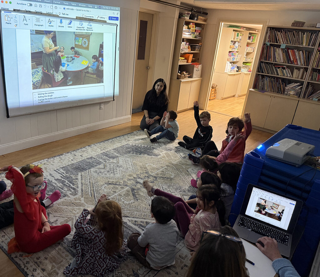 elementary class on the floor in discussion about a projected lesson